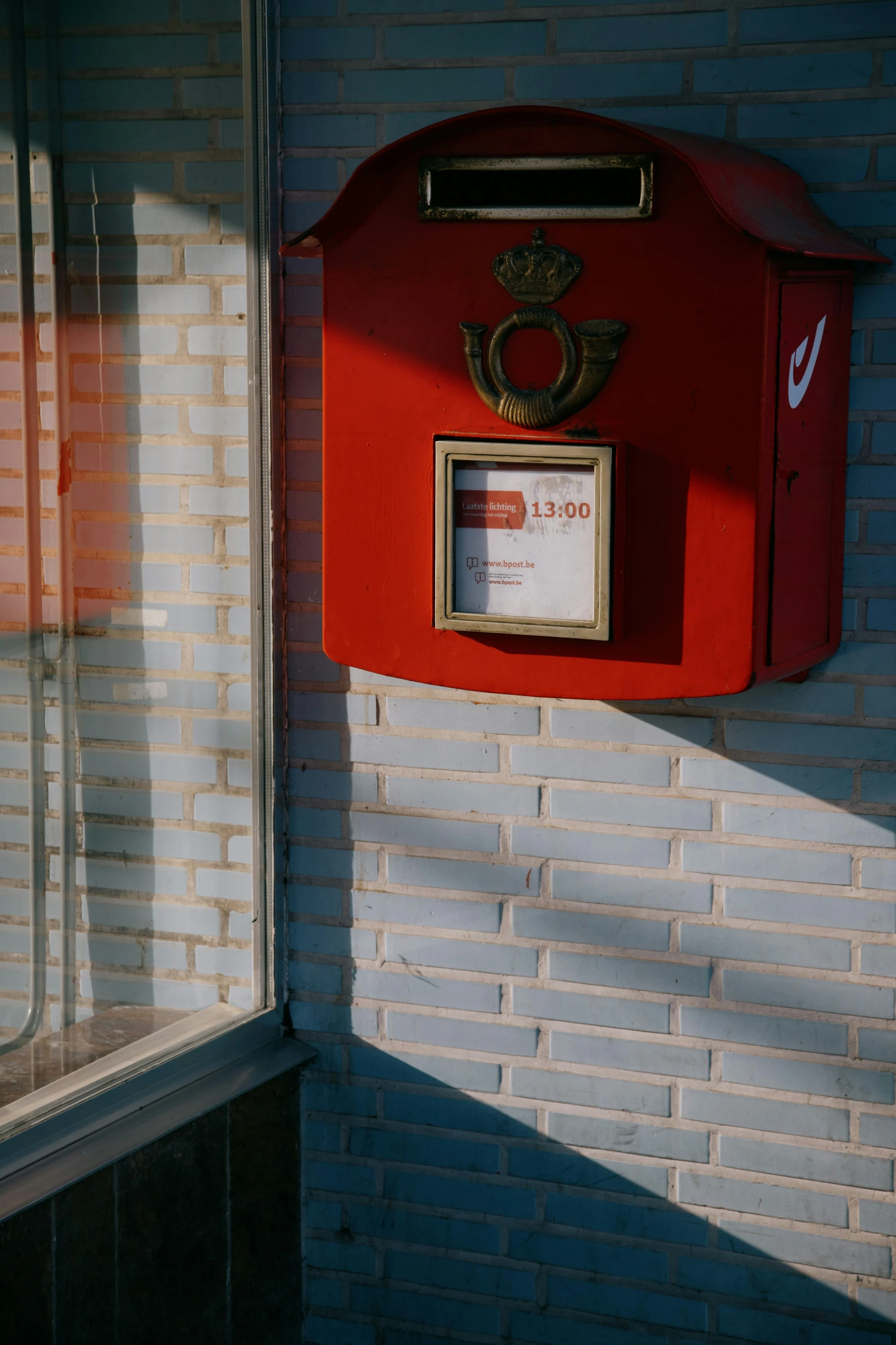 a red mailbox is sitting on the brick wall