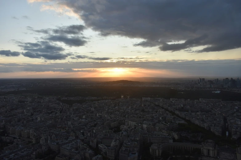 a cloudy sunset behind a cityscape in the background