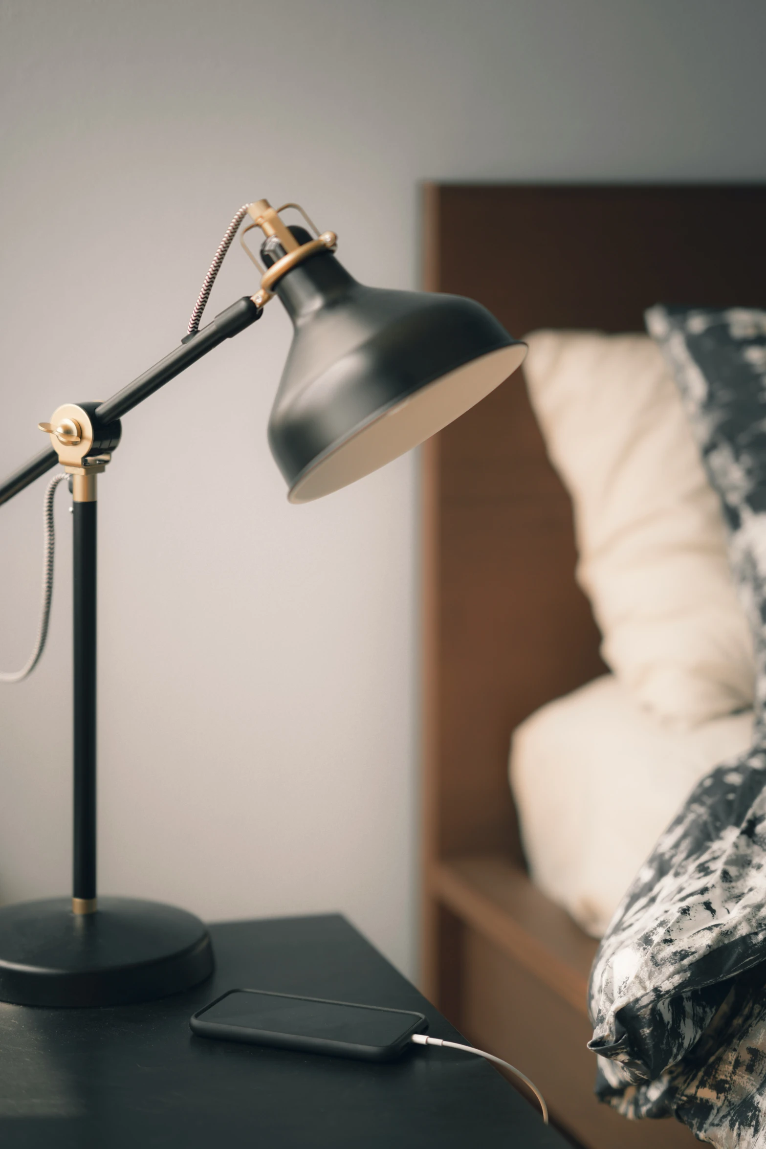 a bedroom with an empty bed next to the bedside table