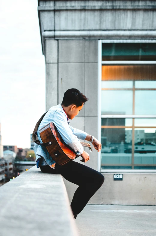 a young man is jumping up into the air with his guitar