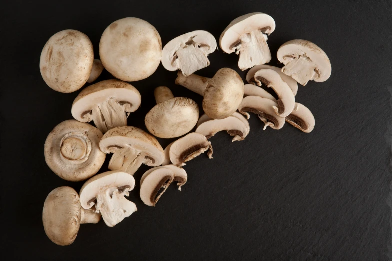 mushrooms and leaves are arranged on a black surface