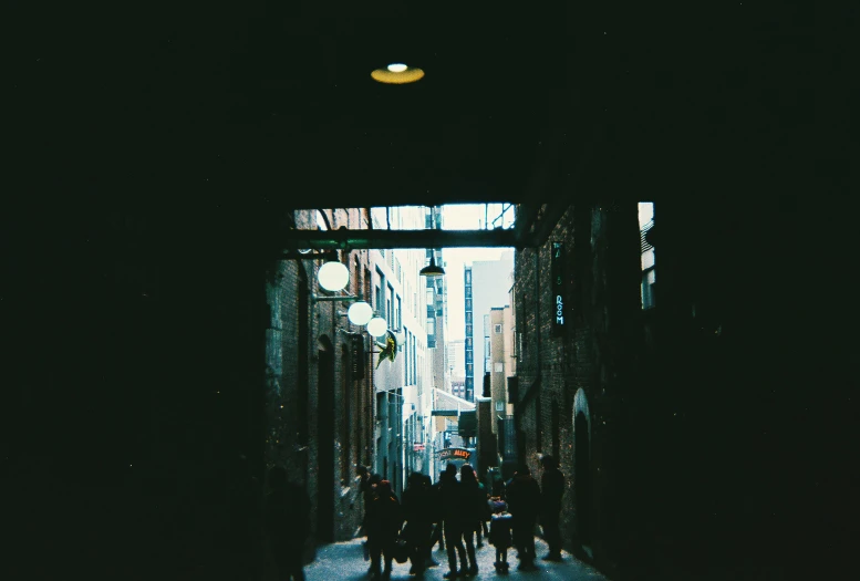 a group of people walking down an alley way