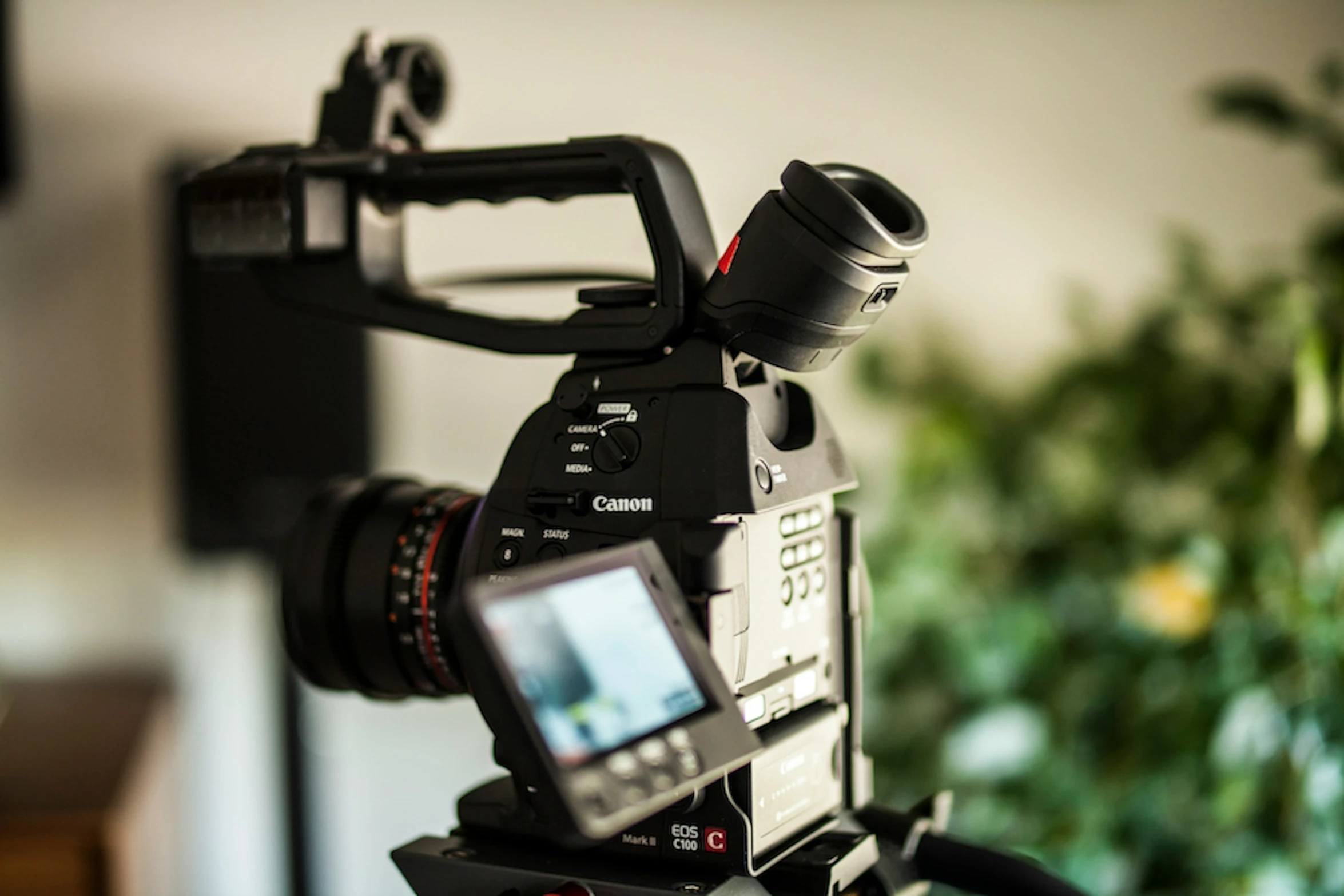 an electronic camera with one lens is on a tripod