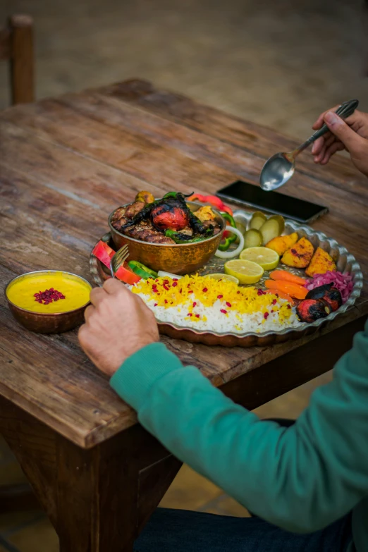 a man sits at the table with a platter of food on it