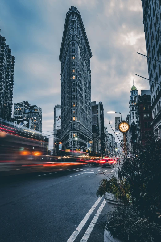 a road with skyscrs at dusk with traffic passing by