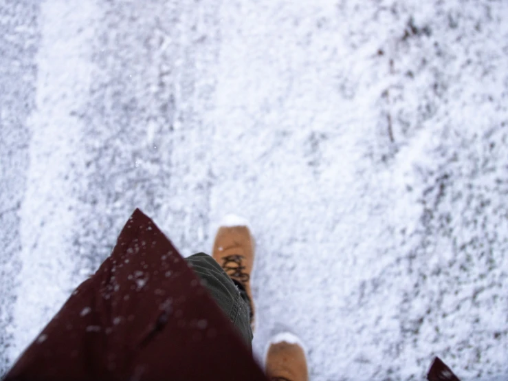 feet with shoes covered in snow above them