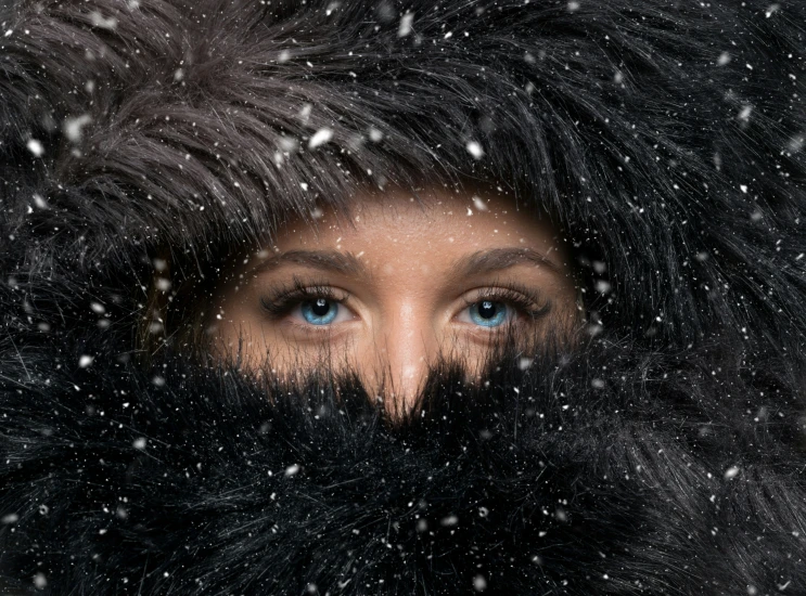 a close up of a person with a long fur and blue eyes