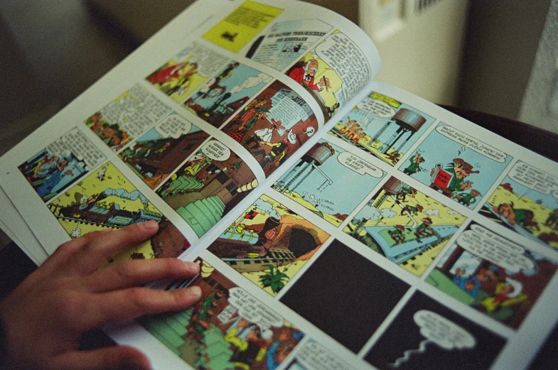 the person is holding a comic book with pages full
