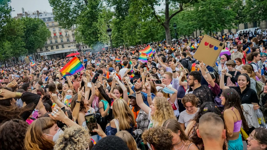 a crowd is celeting at a pride parade