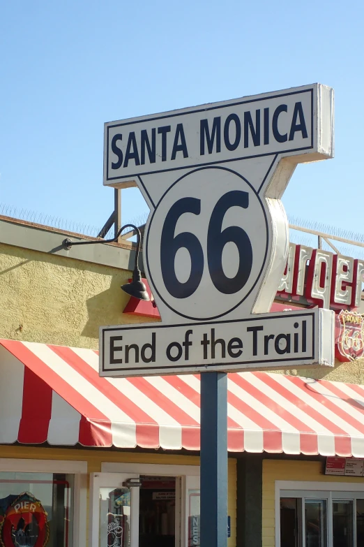 a street sign posted on the corner of santa monica and the end of the trail