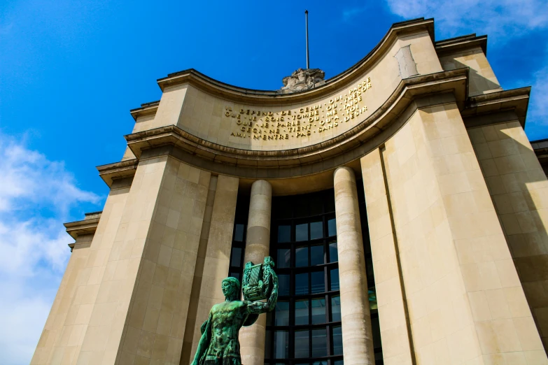 a green statue sitting in front of a building