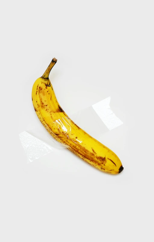 a banana lying on a white surface