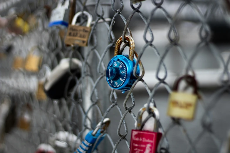 a chain link fence is covered in many padlocks and locks