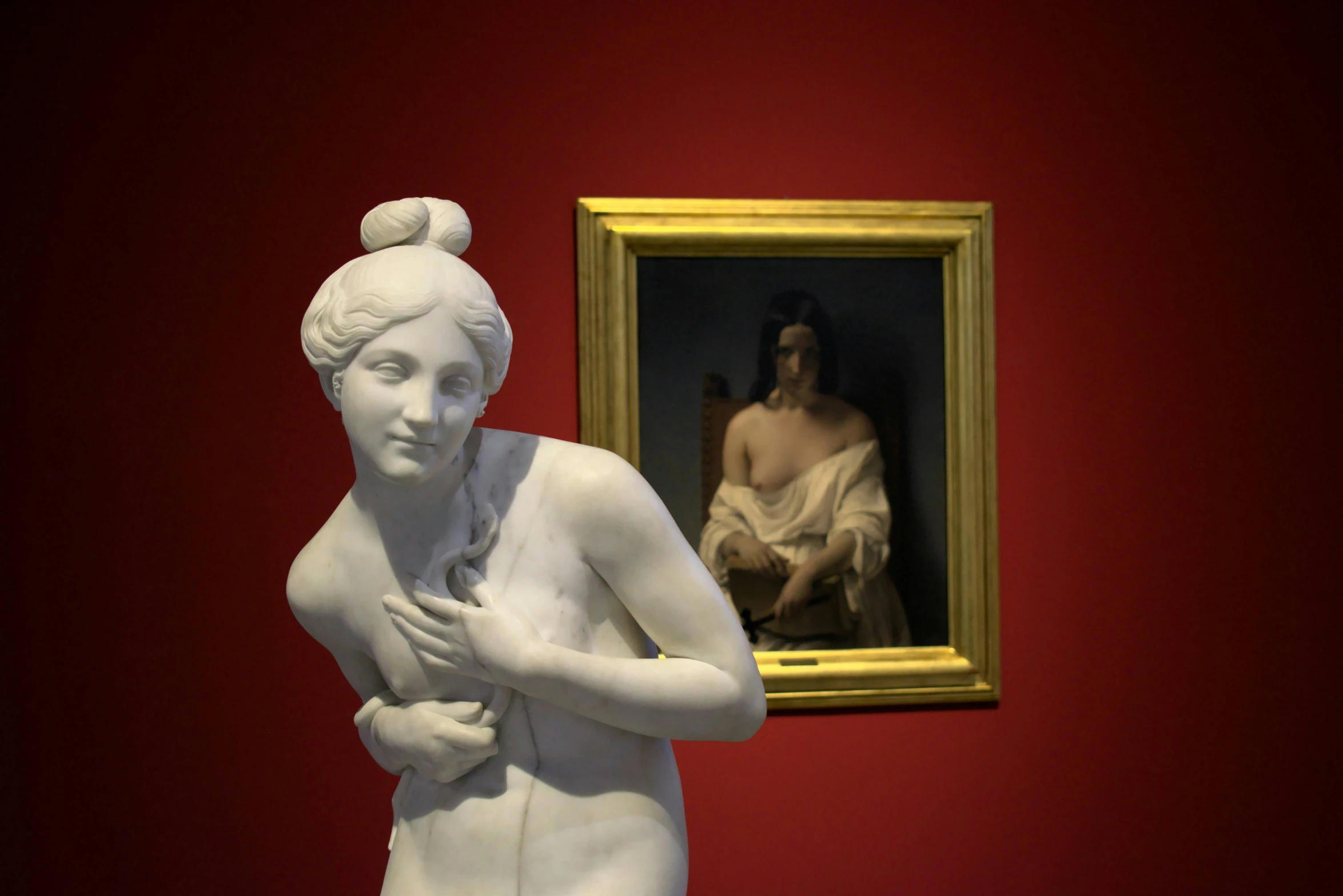 a marble sculpture with a woman beside a painting