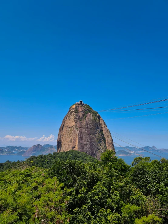 the mountain overlooks trees, with a blue sky in the background