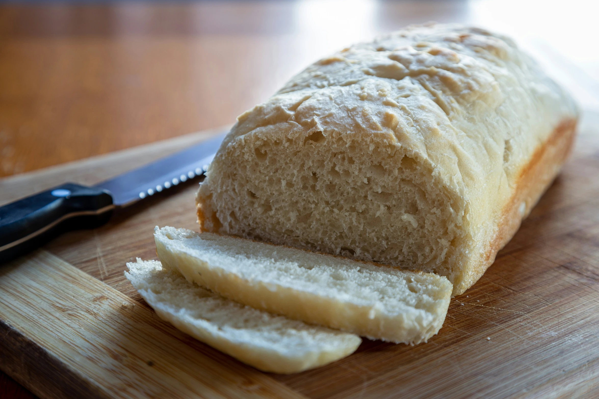 sliced bread with knife sitting on a  board