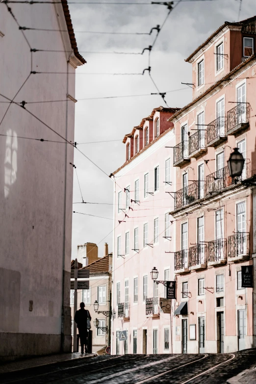 a building and man with a cane walking on a street in front of it