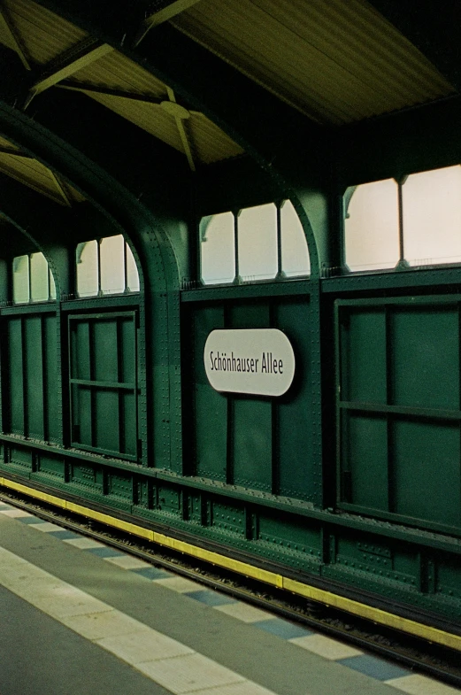 a train station with a sign for commuters at the platform