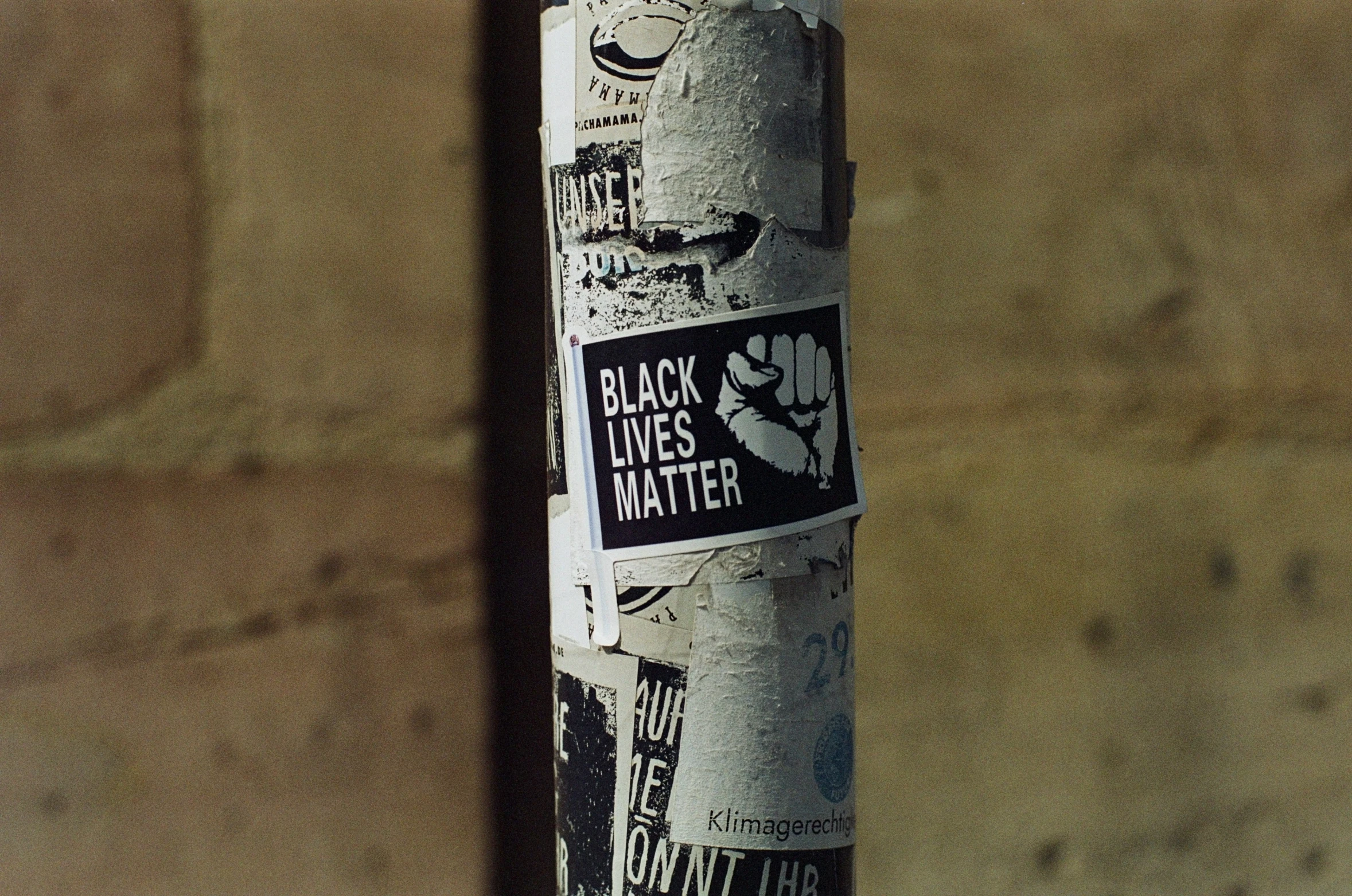 a sticker on a pole with different words posted on it