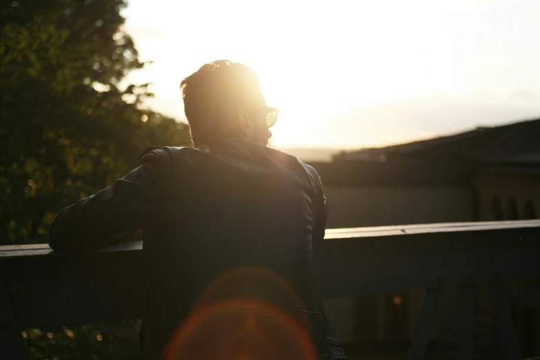 a person standing at the sunset or night with their shadow on the railing