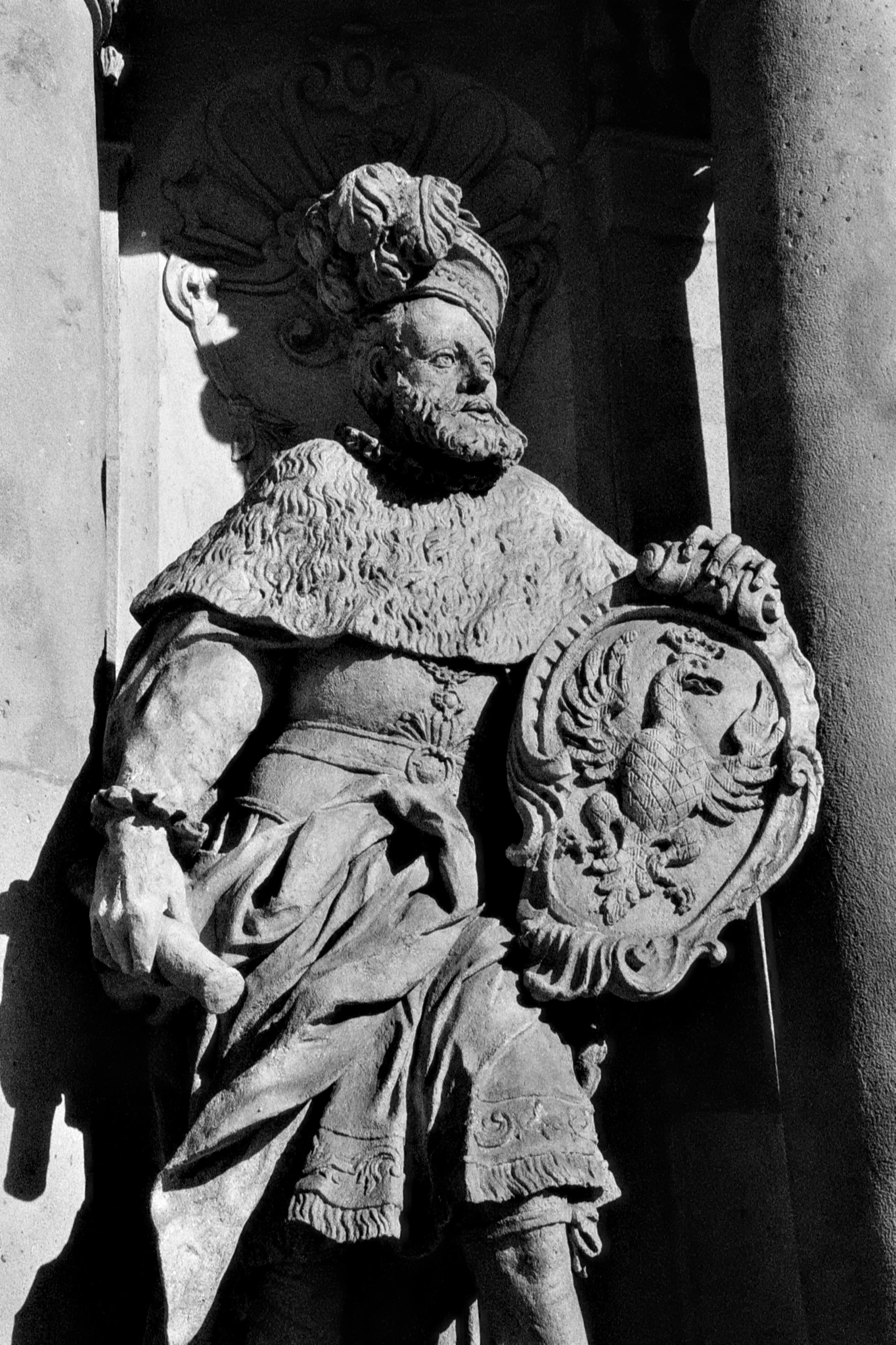 a statue of a seated person with a shield