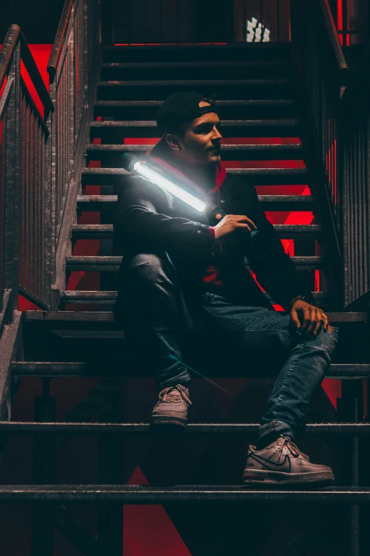 a man sitting on a stairwell with his hands out