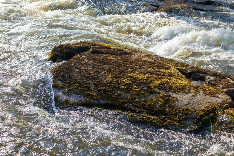 a large rock in the middle of a body of water