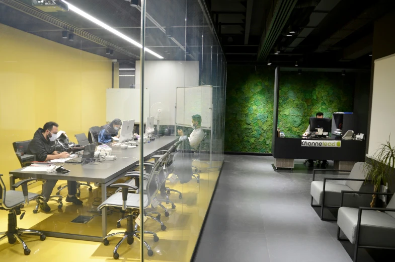 a conference room with long desk and green wall