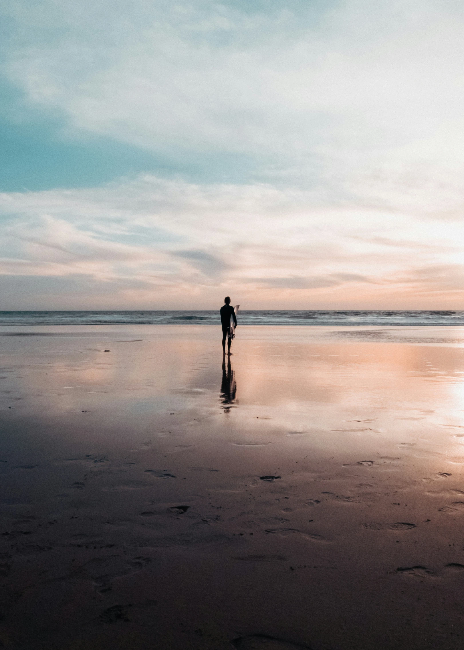 a person standing alone in the water on a beach