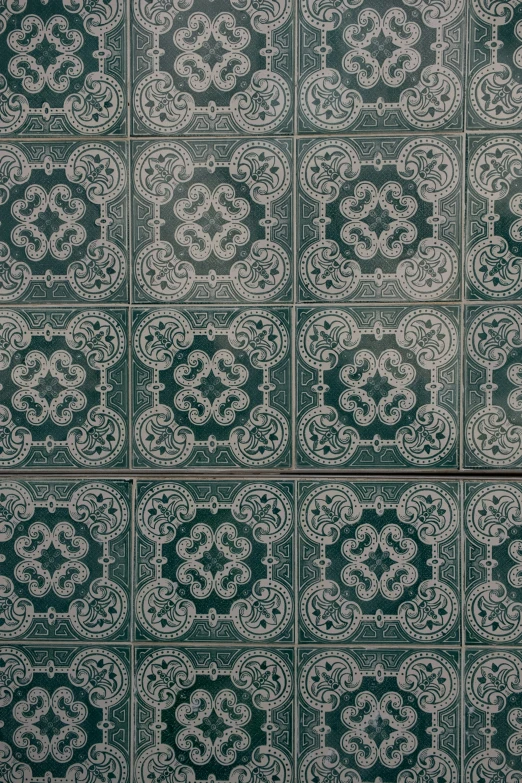 a black and white tile wall with a white ornamental pattern