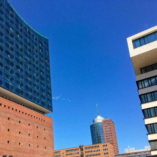 two skyscrs with one tall brick building with large windows