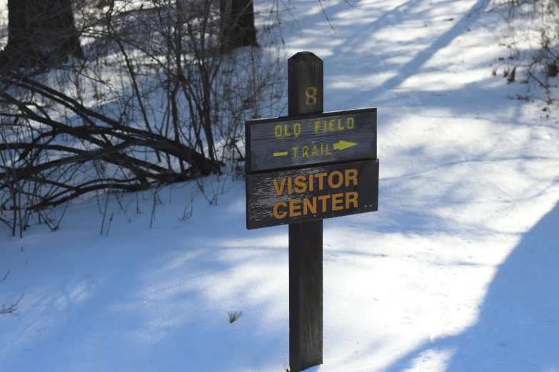 a wooden sign that has the words visitor center on it