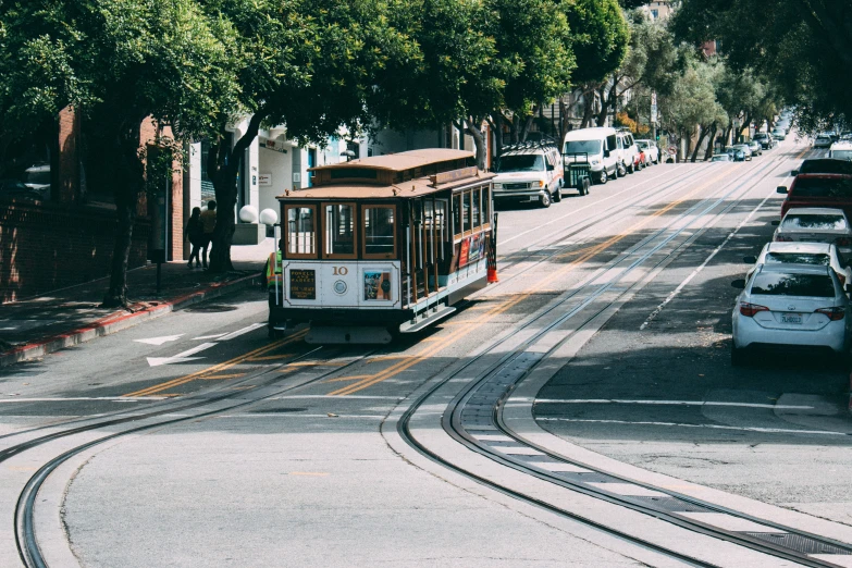 the trolley car drives down the street and turns right at traffic