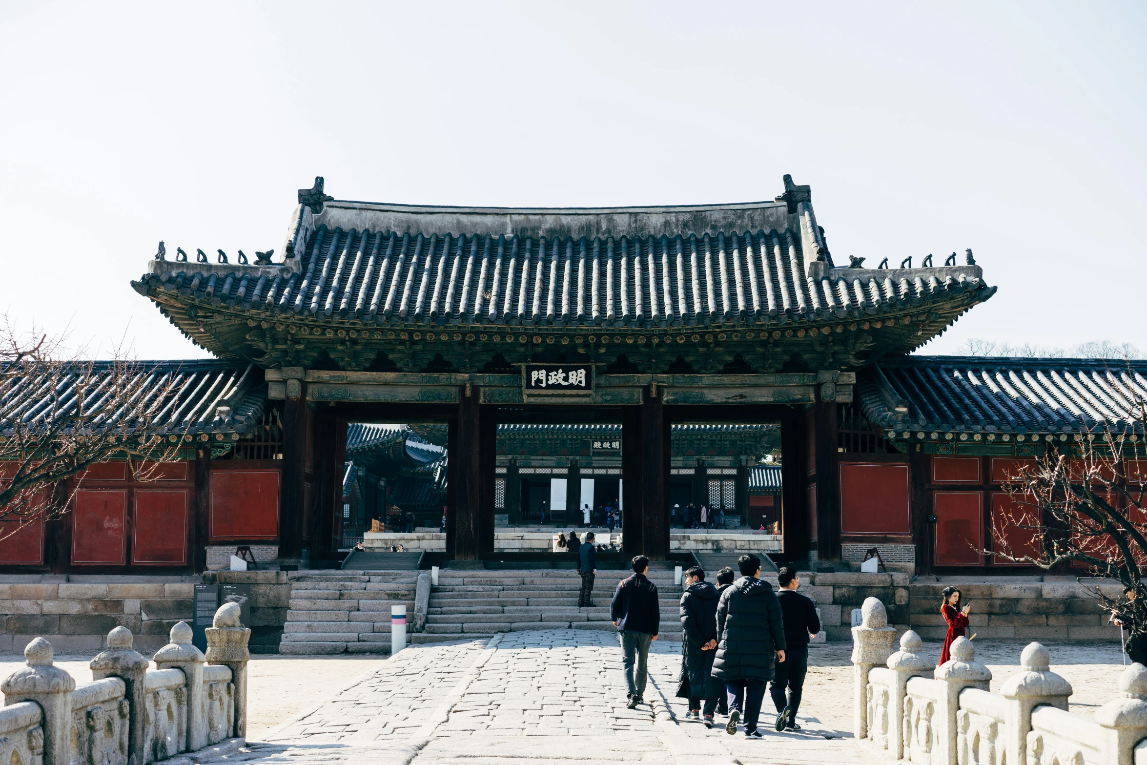 people walking in front of an oriental building with tall columns