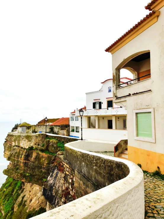 a cliff side apartment building overlooks a vast bay