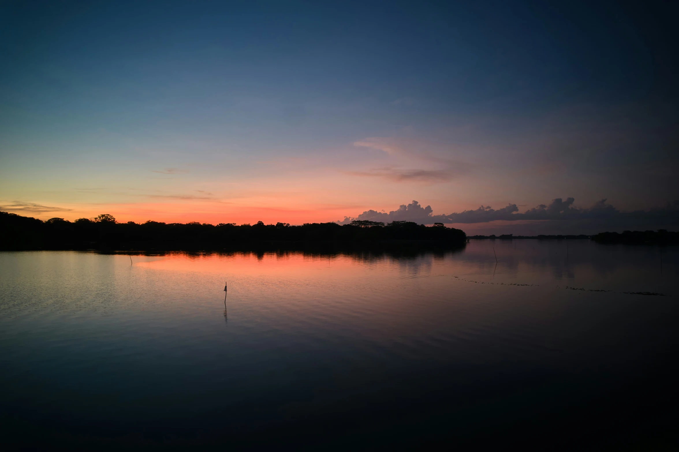 a sunset view of the water in a lake