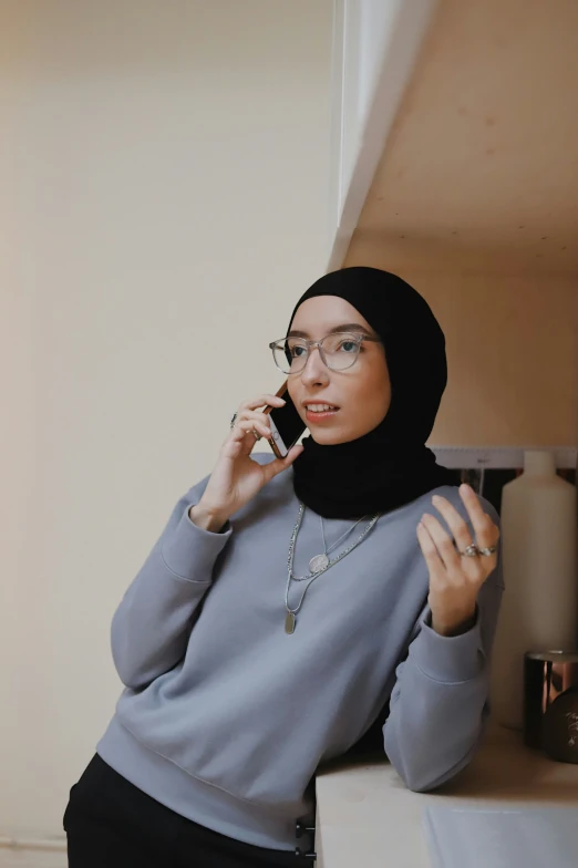 a woman wearing a hijab talking on a phone