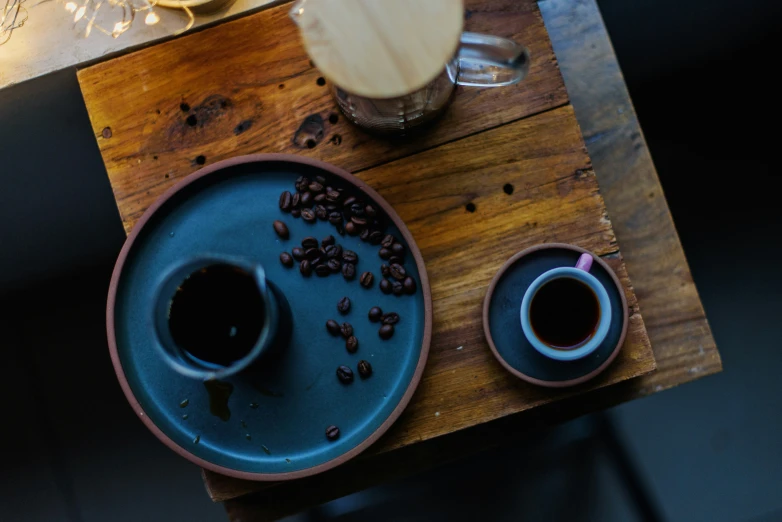 there is coffee and two cups on a table