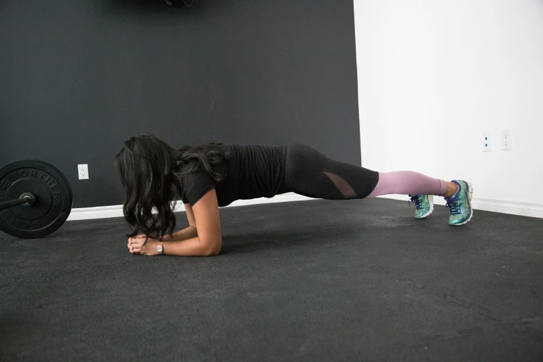 a woman doing a back h with a barbell