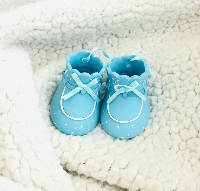 pair of baby shoes resting on a blanket