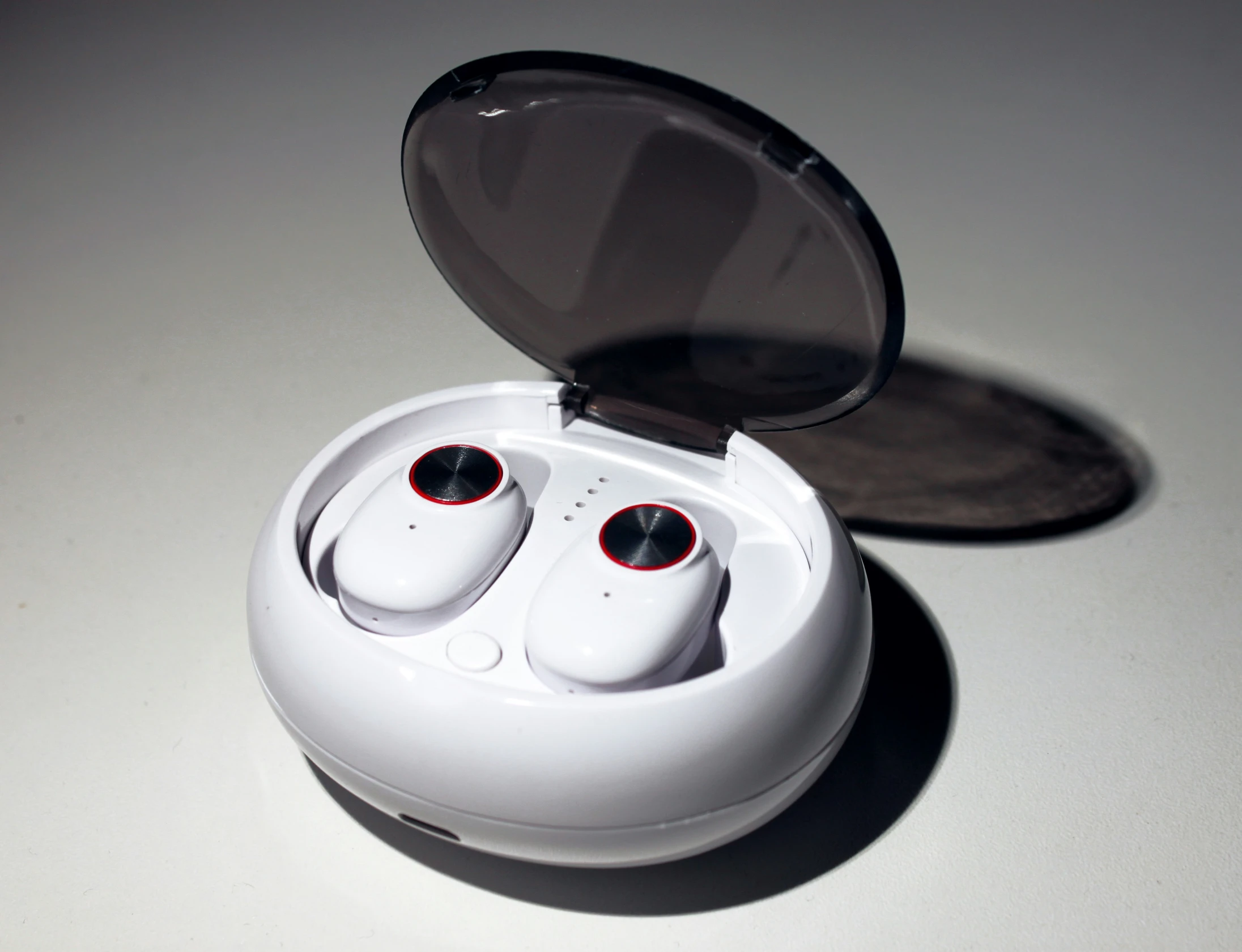 a white pair of earbuds sitting in a plastic case