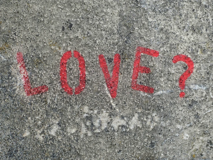 the word love is painted on a cement surface