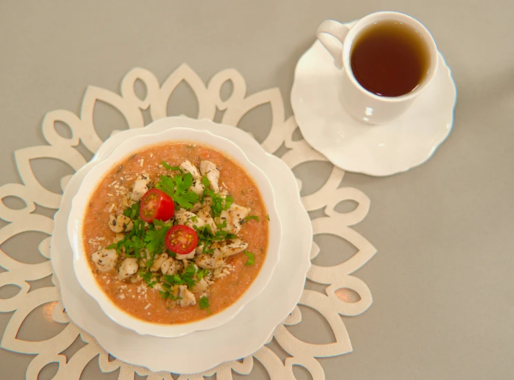 soup served on a white plate and cup of tea