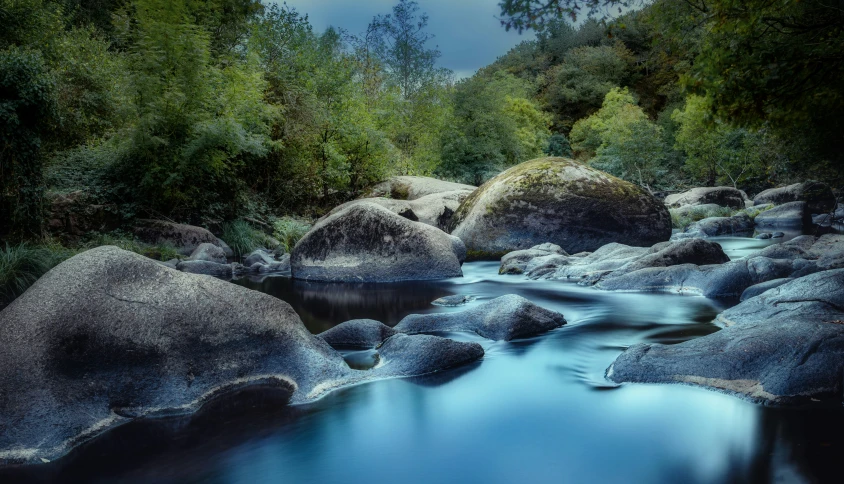 a stream filled with water surrounded by rocks