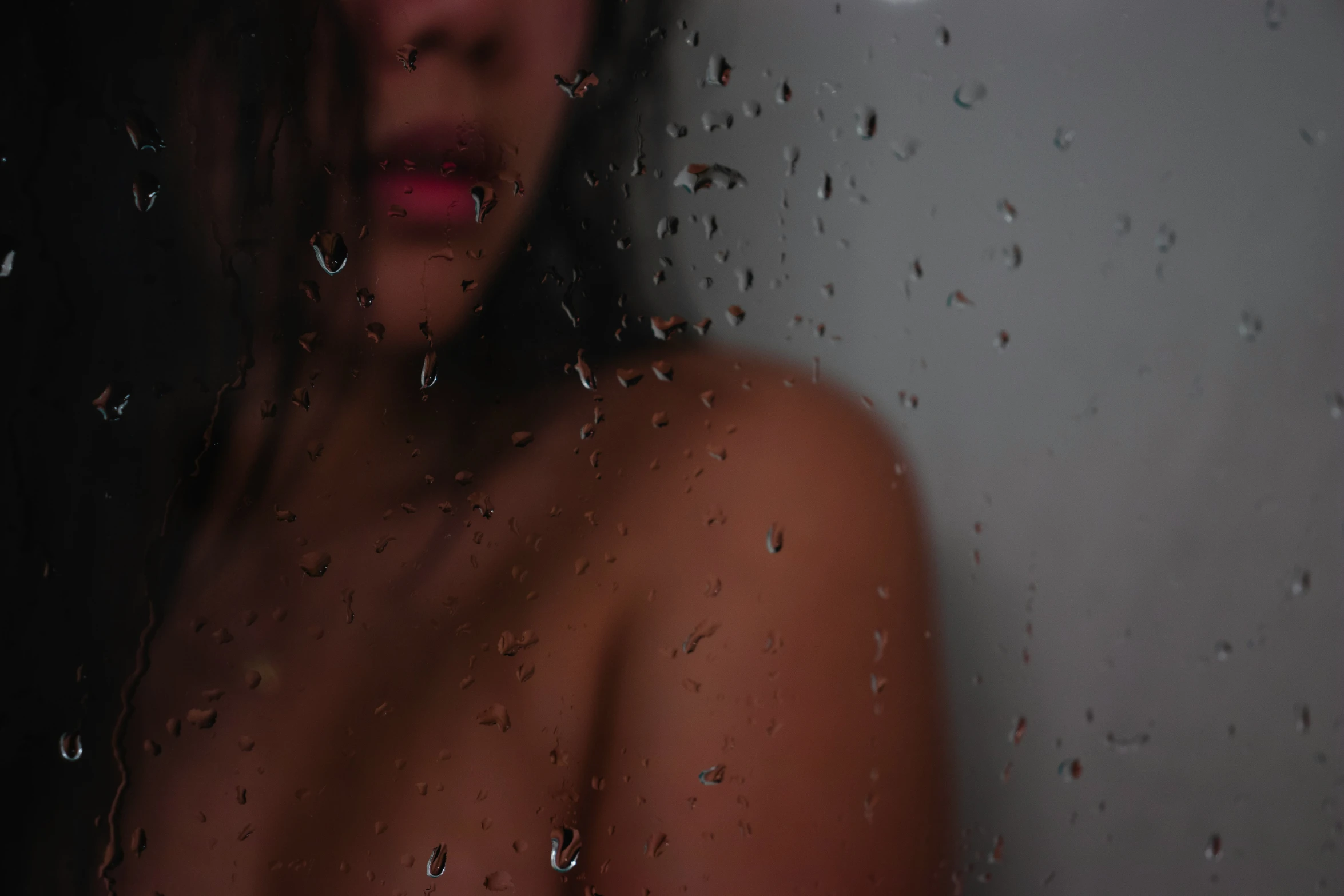 a  young woman sitting in front of rain drops