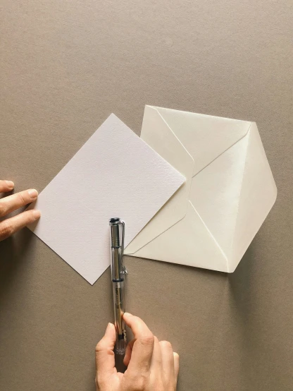 hands are making a geometric design out of folded paper