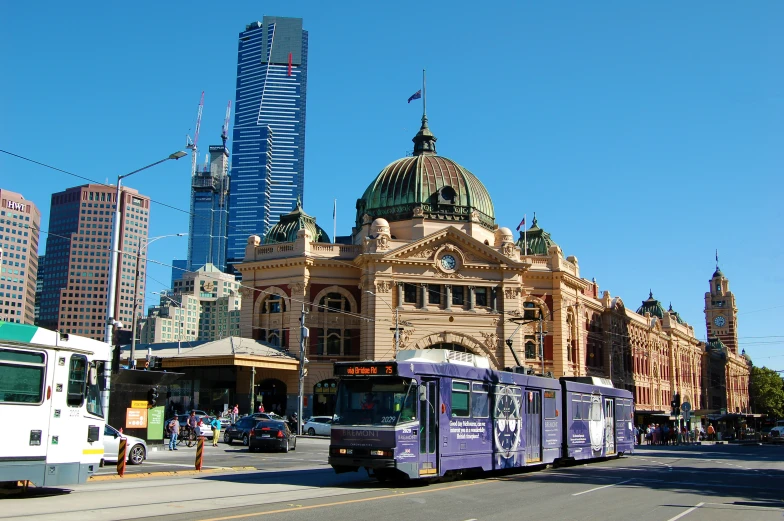 a train on a street in front of an old building