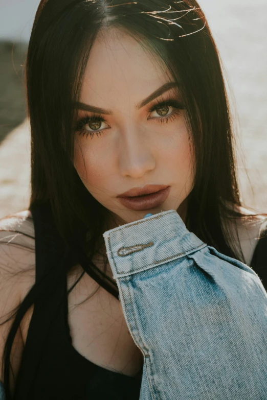 a woman with long black hair and bangs with denim jeans