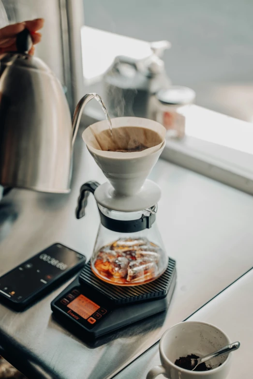 pour - kettle coffee maker and smartphone on small tray with coffee pot