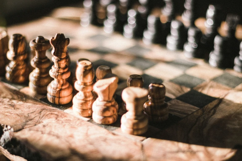 an old chess board with a lot of black and white chess pieces on it